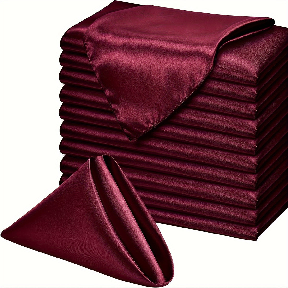 a stack of folded sheets and a satin pillow