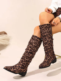 Point toe block heel boots in leopard print, featuring low heels and stylish knee-high design.