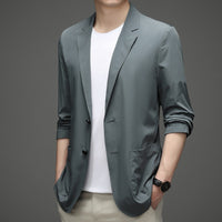 a man wearing a gray blazer and khaki pants