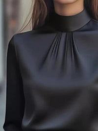 Mock Neck Long Sleeve Blouse with Pleated Detail in elegant black fabric, showcasing pleated design and high neckline.