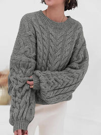 Cozy gray cable knit long sleeve sweater featuring a relaxed fit and oversized sleeves.