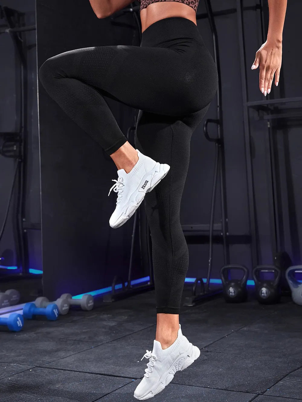 High waist active leggings in black, ideal for workouts, paired with stylish sneakers in a gym setting.