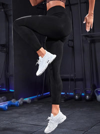 High waist active leggings in black, ideal for workouts, paired with stylish sneakers in a gym setting.