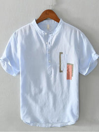 Men's plus size geometric contrast half-button t-shirt in light blue with stylish graphic patches.