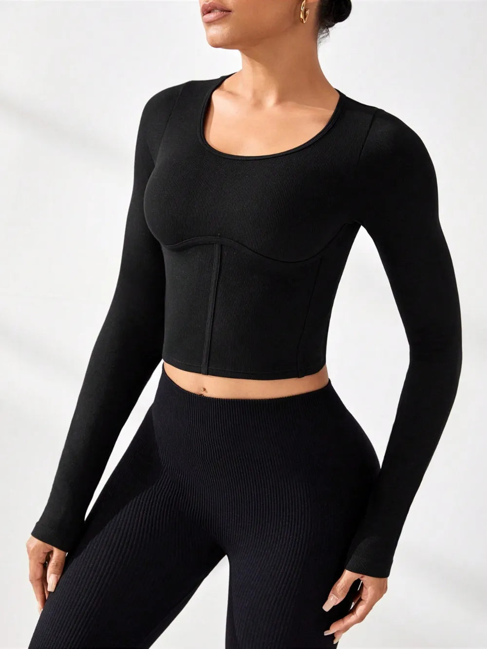 Model wearing a black round neck long sleeve active t-shirt with matching leggings, showcasing affordable activewear.