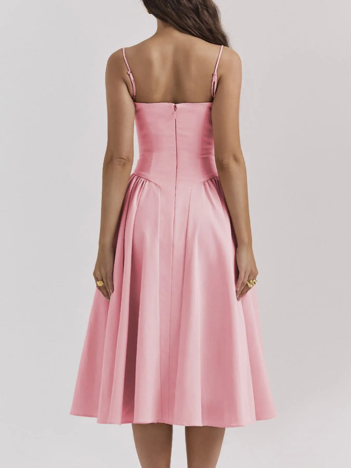 Back view of a pink ruched sweetheart neck cami dress with a flared skirt and adjustable straps.