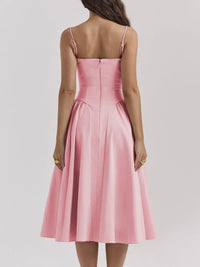 Back view of a pink ruched sweetheart neck cami dress with a flared skirt and adjustable straps.