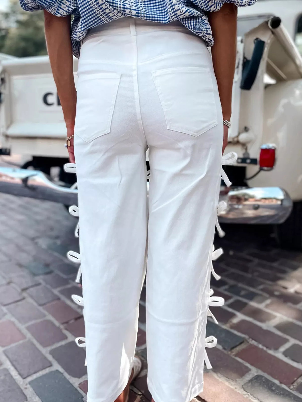 Back view of Bow-Accented Wide-Leg Pants featuring white fabric with stylish bows on the sides.