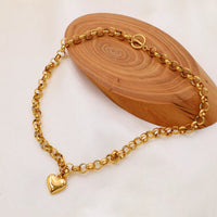 Heart Pendant Toggle Clasp Chain Necklace displayed on wooden surface, showcasing its gold-plated design and heart charm.