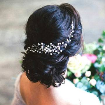 a woman wearing a bridal hair comb with flowers in the background