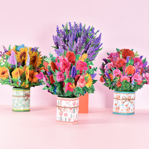 a group of three vases filled with colorful flowers