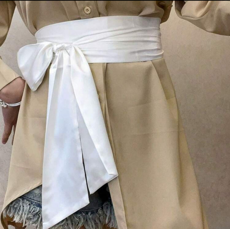 Elegant white bridesmaid waist sash tied in a bow, enhancing a chic outfit with a timeless ribbon silhouette.