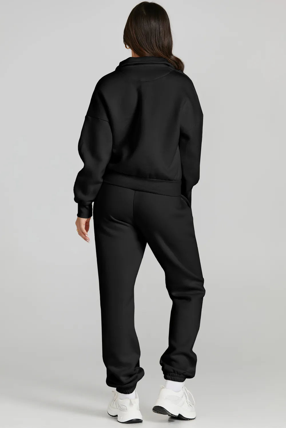Back view of a woman wearing a black quarter zip top and drawstring pants active set, showcasing affordable activewear.