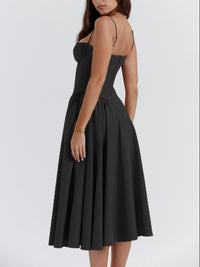 Back view of a women's ruched sweetheart neck cami dress in black, featuring a flowy skirt and adjustable straps.