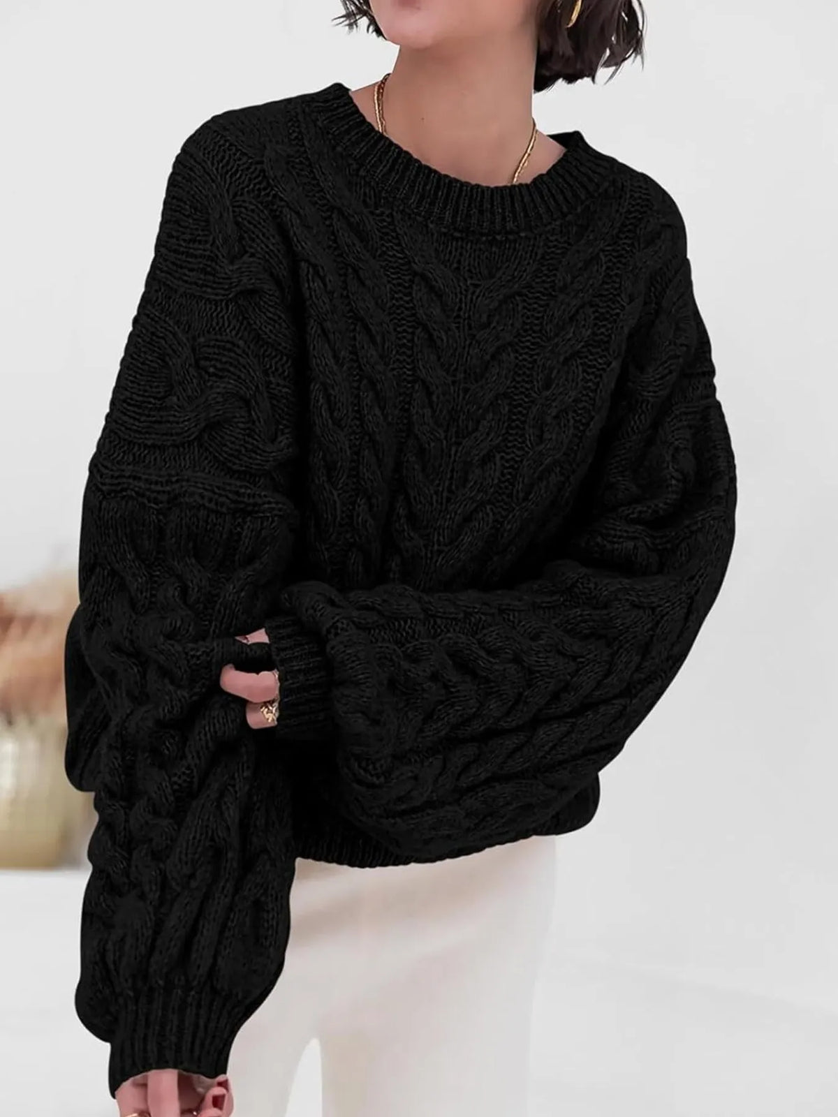 Black cable knit long sleeve sweater featuring a relaxed fit and cozy texture, perfect for casual style.