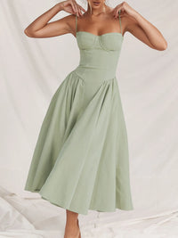Ruched sweetheart neck cami dress in light green, featuring a flowing skirt and adjustable straps.
