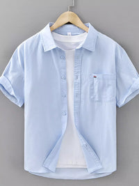 Men's plus size plaid button-up short sleeve shirt in light blue with pocket detail.