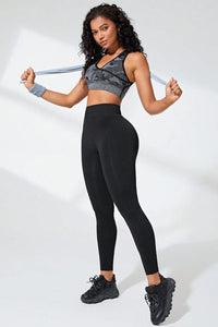 Model wearing high waist active leggings paired with a sporty crop top and sneakers, showing stylish athletic wear.