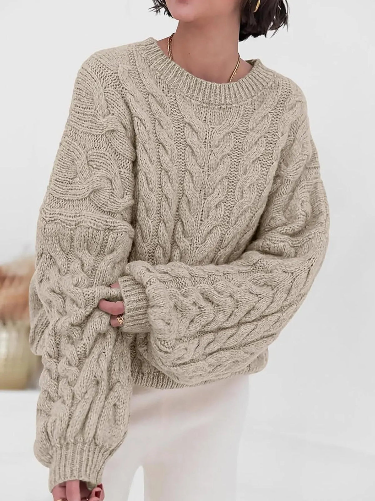 Stylish woman wearing a beige cable knit long sleeve sweater, perfect for cozy autumn outfits.