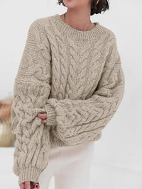 Stylish woman wearing a beige cable knit long sleeve sweater, perfect for cozy autumn outfits.
