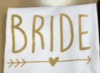 a white towel with a gold arrow and the word bride on it