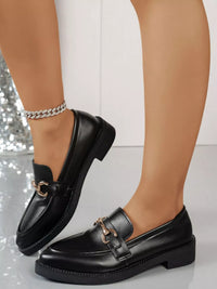 Point toe black block heel loafers displayed on a model, showcasing stylish PU leather design with chain detail.
