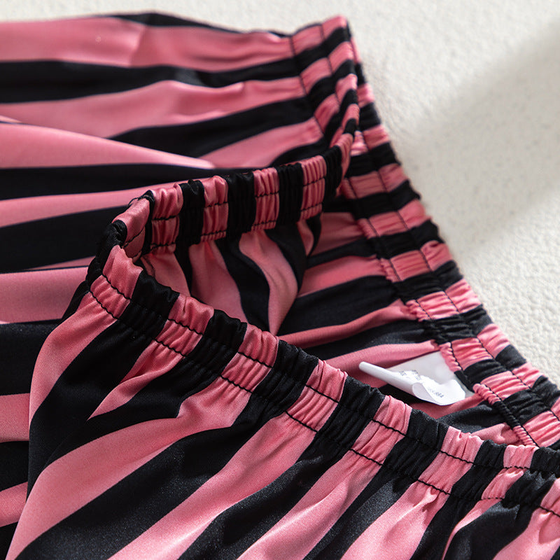 Close-up of pink and black striped fabric showcasing elastic waistband of a home wear suit.