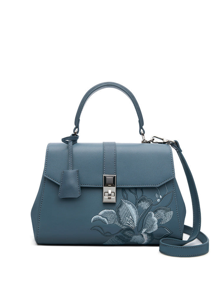 a blue handbag with a floral design