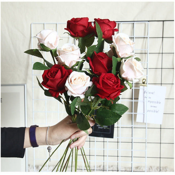 a person holding a bunch of red and white roses