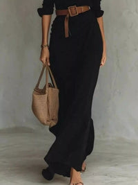 Full Size Ruched Long Sleeve Maxi Dress Plus Size in black, featuring a belted waist and stylish tote bag.