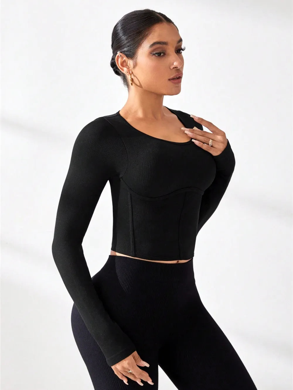Model wearing a black round neck long sleeve active t-shirt, showcasing a sleek and stylish athletic look.