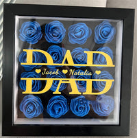 a framed picture of blue roses with a dad's day message