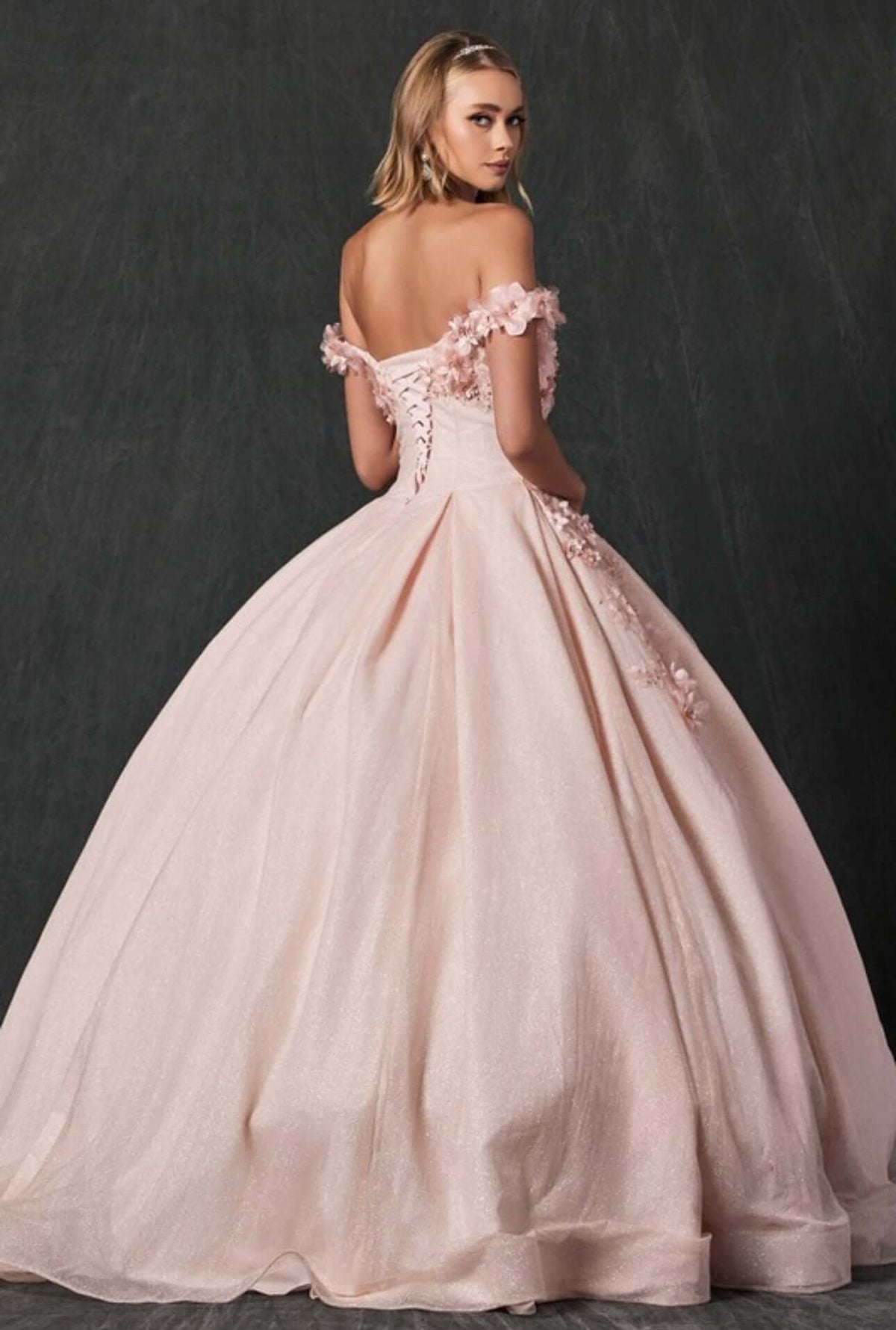 a woman in a ball gown with a flower on the back