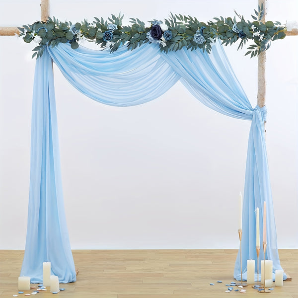 a blue wedding arch decorated with greenery and candles