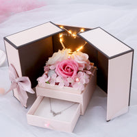 a white box with a pink rose inside of it