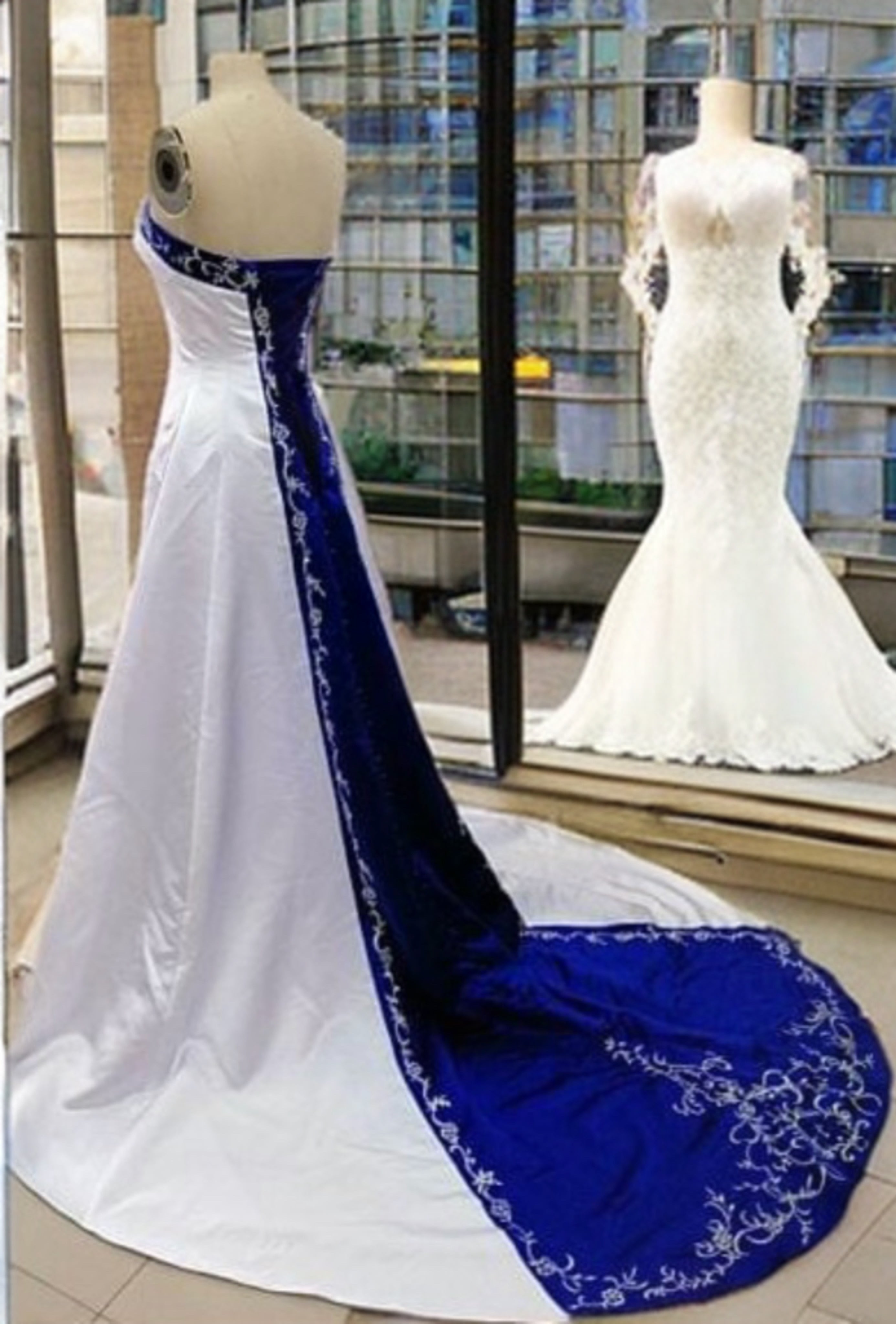 a white and blue wedding dress on display in a window