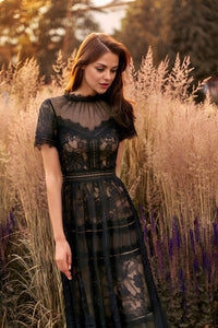 Elegant black evening dress with lace detailing, short sleeves, and a floor-length silhouette.