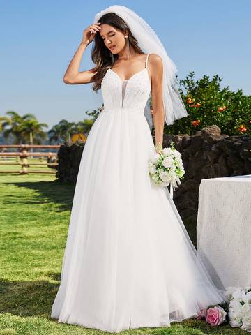 a woman in a wedding dress standing in the grass