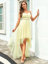 a woman in a yellow dress leaning against a wall