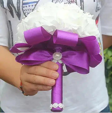 a person holding a purple and white bouquet