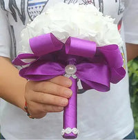 a person holding a purple and white bouquet