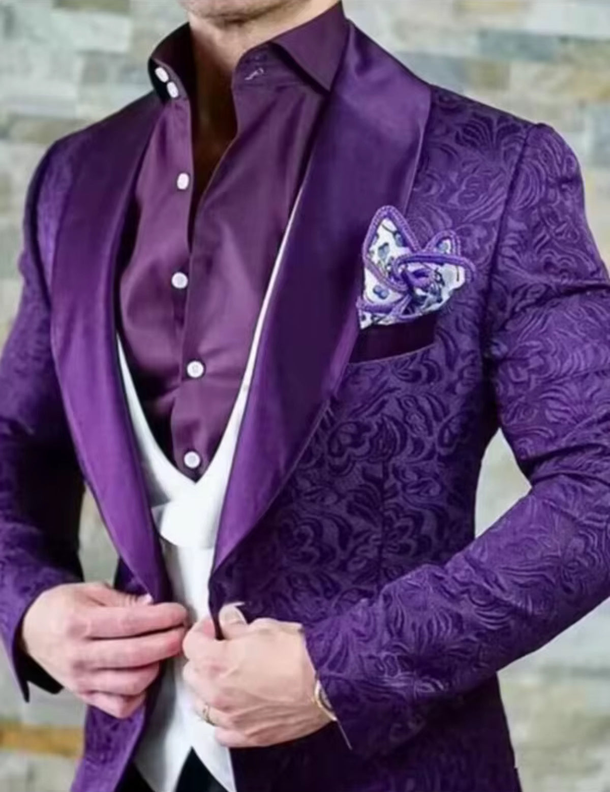 Men's purple jacquard paisley tuxedo with a stylish waistcoat and pocket square, showcasing modern formal fashion.