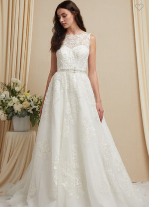 a woman in a wedding dress standing in front of a flower arrangement