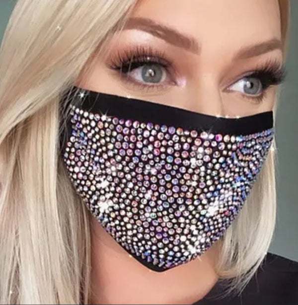 a woman wearing a face mask with lots of crystals on it