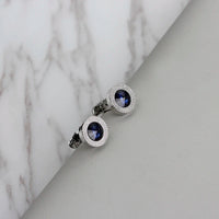 a pair of blue stone earrings on a marble surface