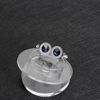 a pair of blue crystal earrings sitting on top of a plastic container