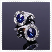 a pair of cufflinks with a blue stone