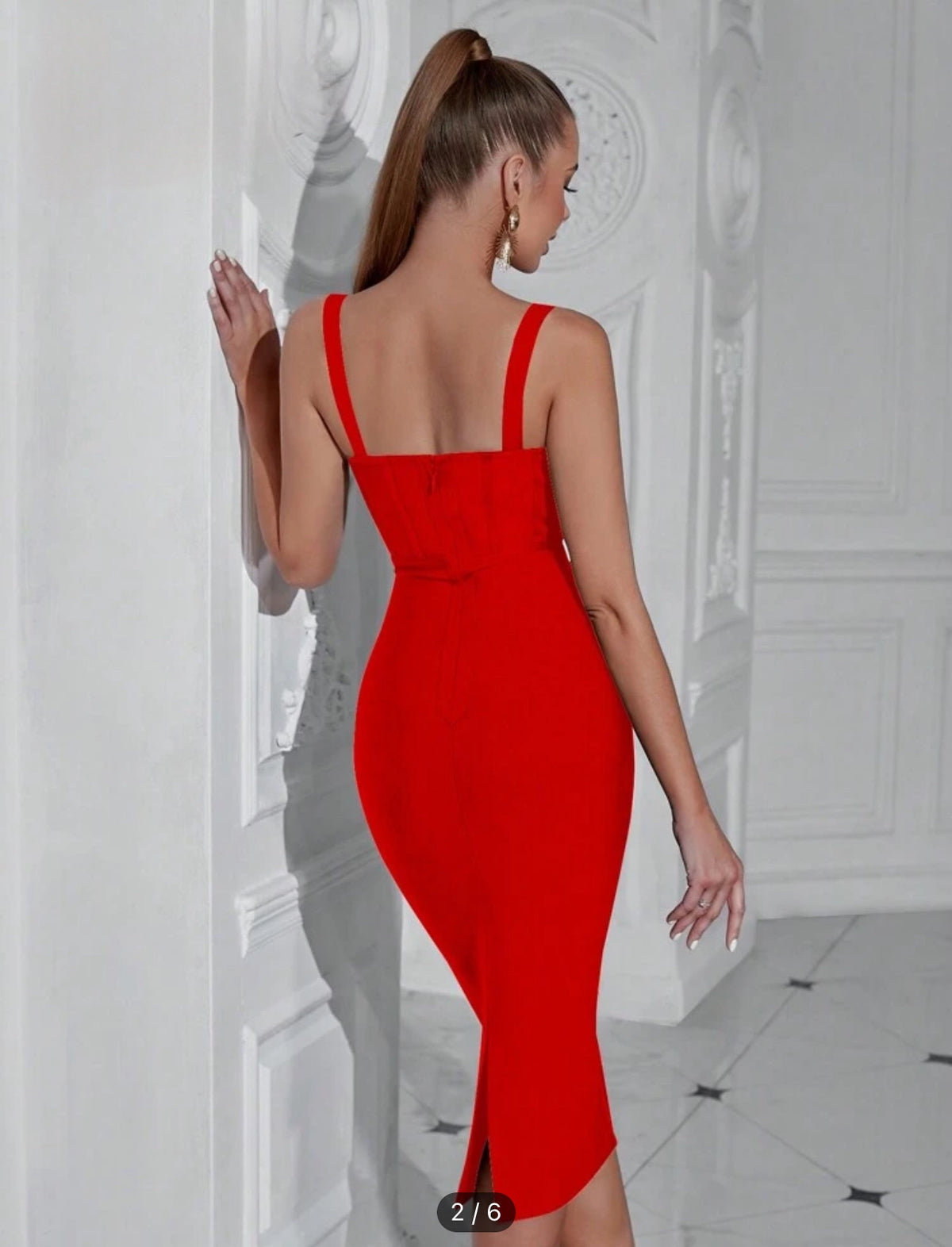 a woman in a red dress standing in front of a wall