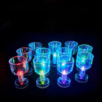 a group of lit up glasses sitting on top of a table