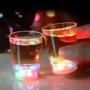 two glasses of water with colored lights in them